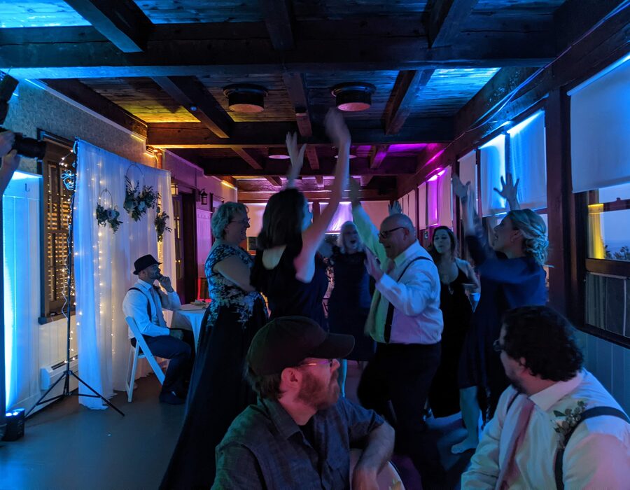 Guests dancing under multicolor DJ lights